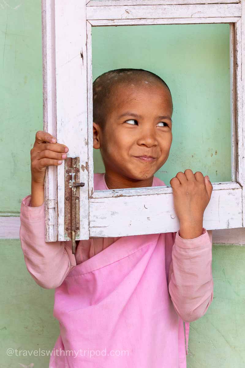 A young student smiles through a window at the Aung Myae Oo Monastic Free Education School in Myanmar