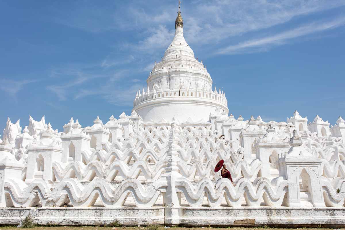 A young monk sits on the wall of the Hsinbyume Pagoda in Mingun, Myanmar