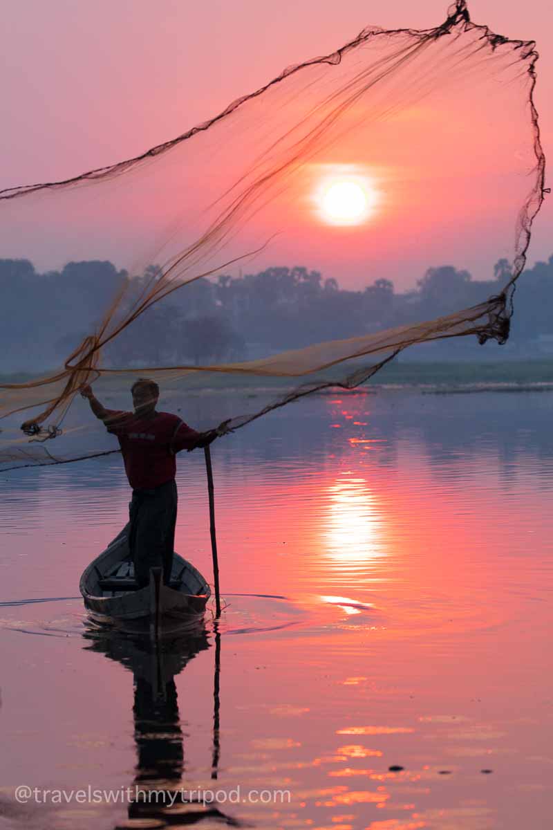 A fisherman throws his net on Taungthaman Lake in Myanmar at sunrise