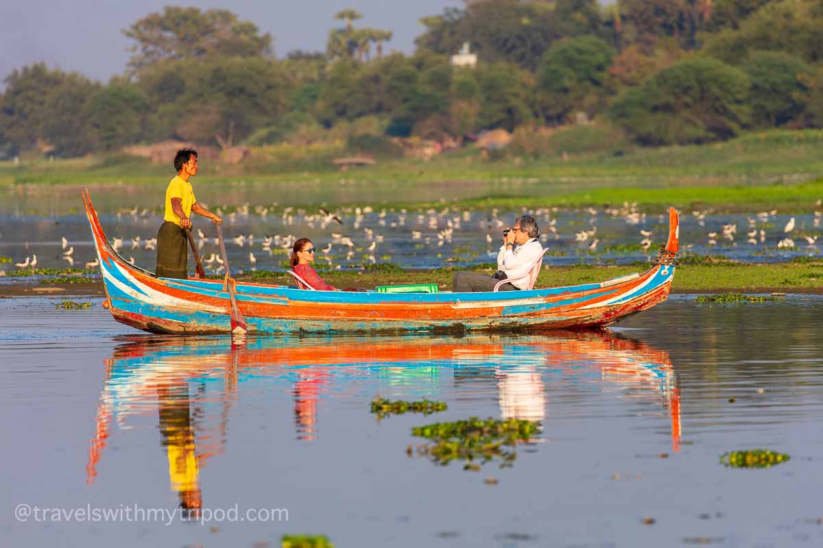 A couple of tourists in a small boat on Taungthaman Lake near Mandalay, Myanmar